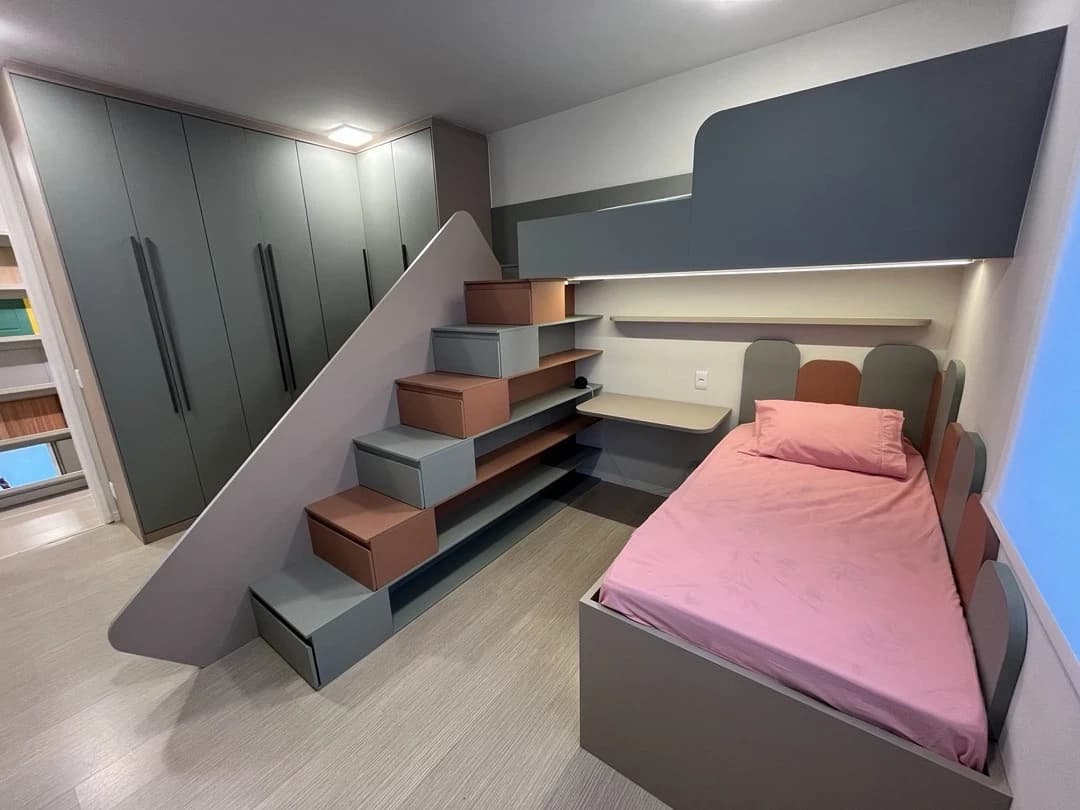 Quarto Infantil Moderno e Funcional: Espaço otimizado com móveis planejados em tons de cinza e detalhes em rosa, destacando a funcionalidade e o design contemporâneo.