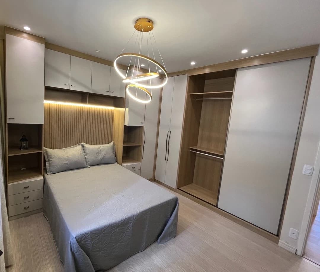 Quarto Moderno com Iluminação Elegante: Ambiente moderno com tons neutros e detalhes em madeira. Mobiliário funcional, aproveitando o espaço de forma inteligente, com iluminação suave e destaque para o painel atrás da cama.