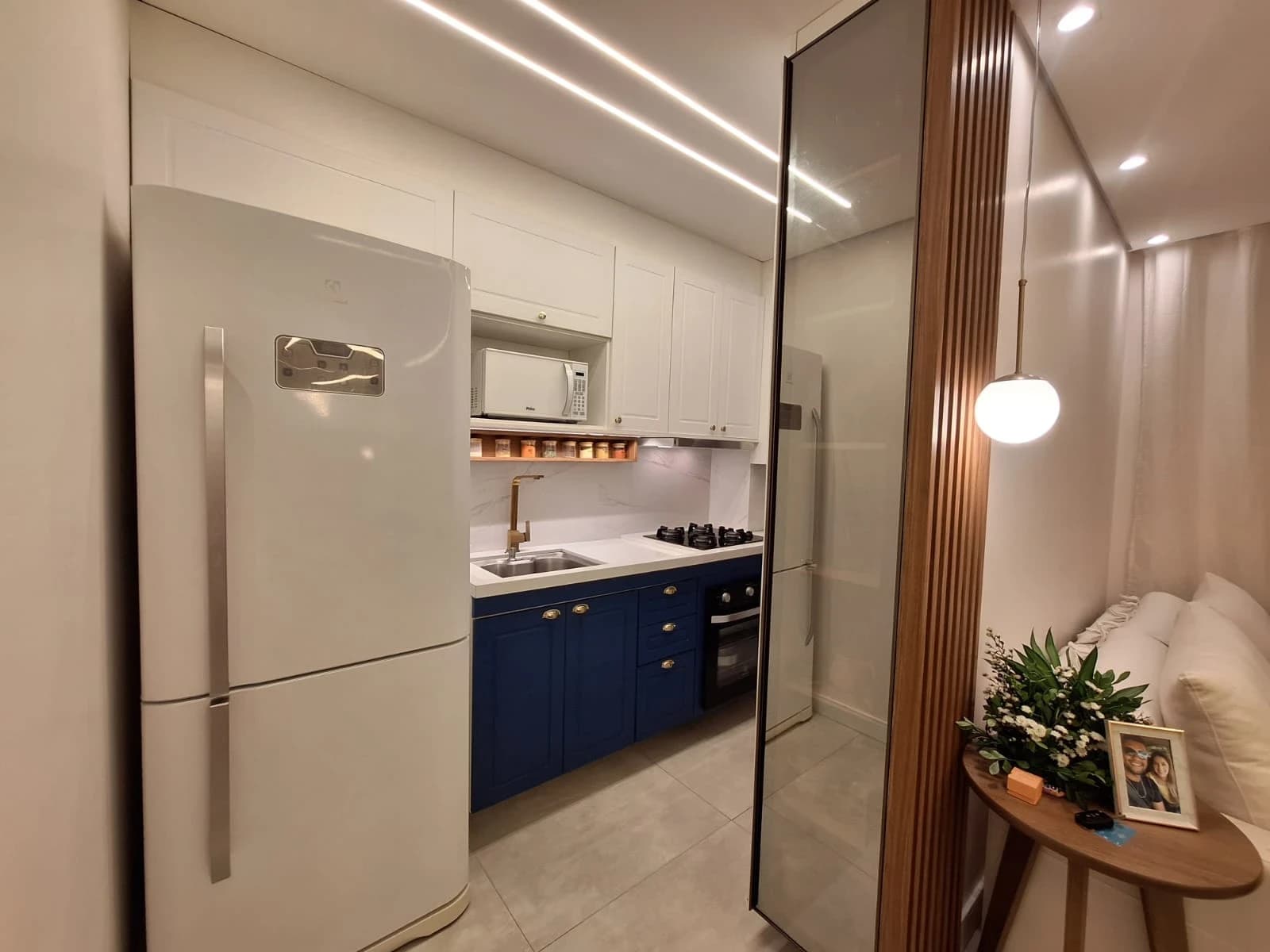 Cozinha Moderna com Toques Elegantes: Ambiente em estilo moderno, com armários brancos e detalhes em azul. Materiais como vidro e madeira trazem funcionalidade e sofisticação ao espaço.