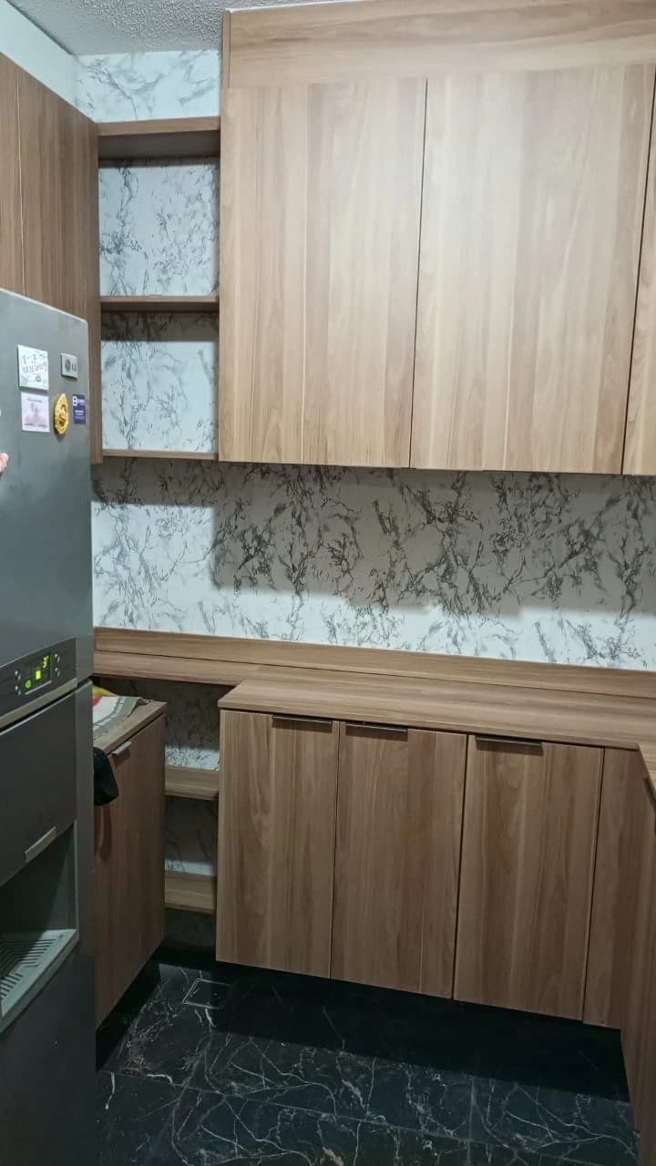 Cozinha Moderna com Acabamentos Elegantes: Ambiente contemporâneo com armários de madeira clara e azulejos marmorizados, destacando a funcionalidade e a estética minimalista.